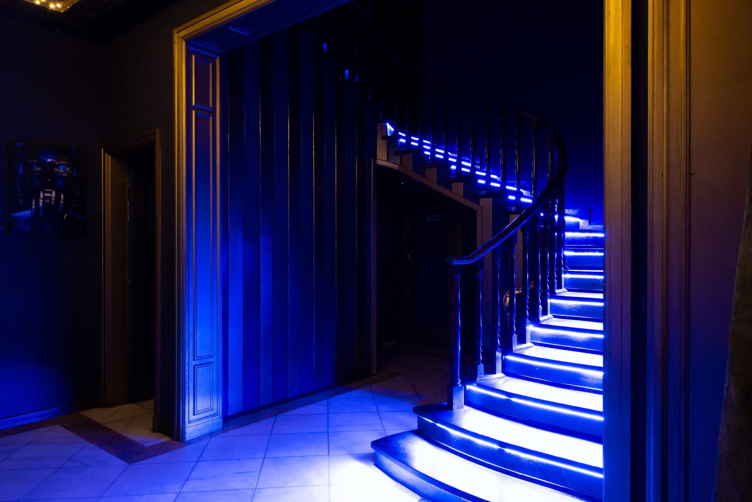 Illuminated staircase with blue LED lighting at Club Oops Barcelona, creating a dramatic nightclub interior atmosphere