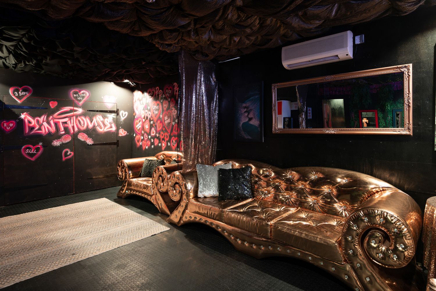 A dark cozy adult club interior with neon lights, graffiti art and industrial decor creates an underground party atmosphere.
