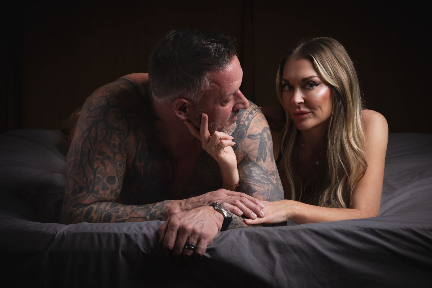 An intimate couple's boudoir photo featuring romantic poses on a bed at a studio in London.