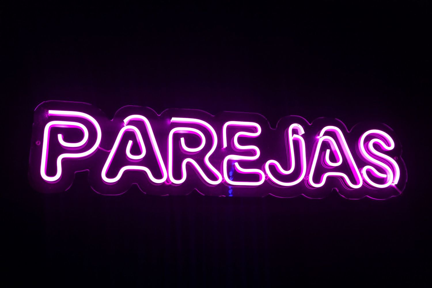 Purple neon signage glowing against dark walls at Club Oops Barcelona, adding to the moody nightclub interior atmosphere