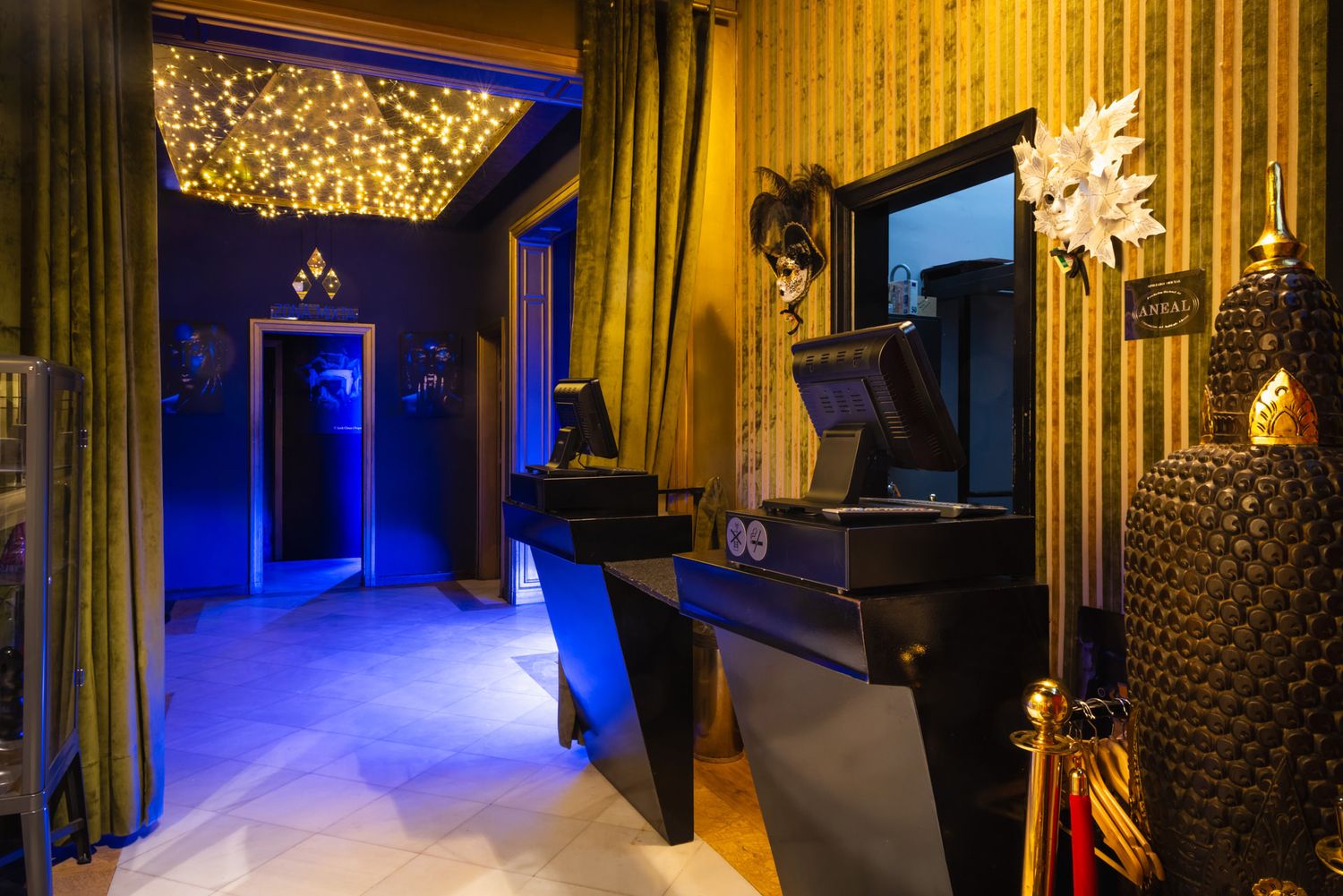 Luxurious spa hallway with blue LED lighting and crystal chandeliers creating a dramatic ambiance.