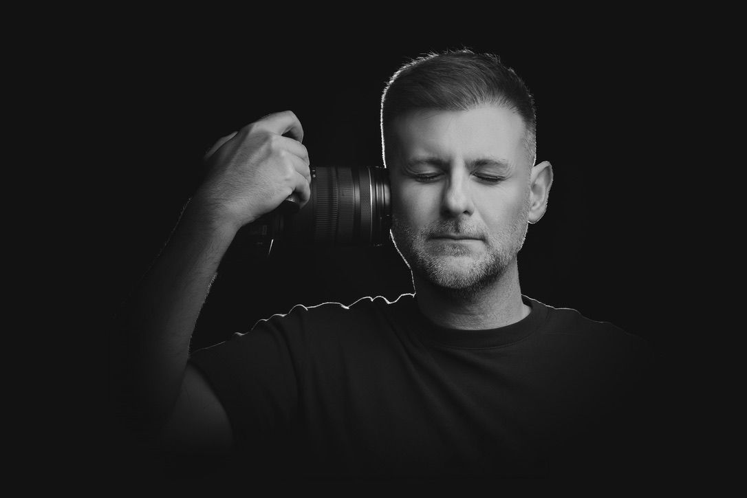 Black and white headshot of male photographer in dramatic studio lighting - professional portrait for boudoir photographer about page