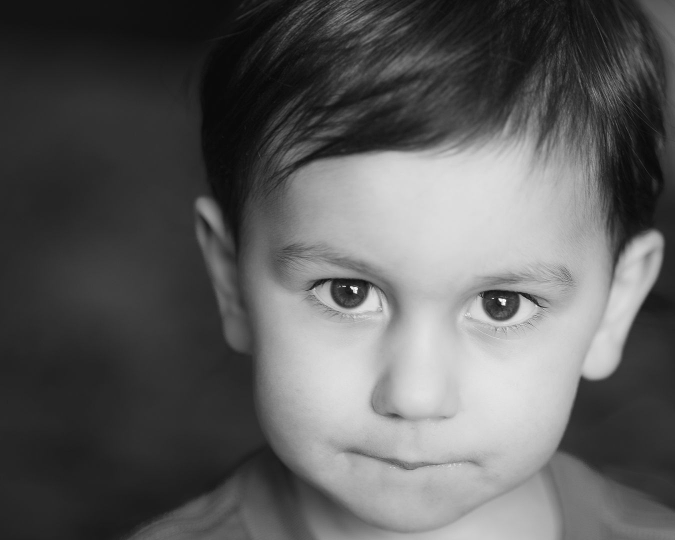 Close-up black and white portrait of a young toddler with dark eyes and short hair.