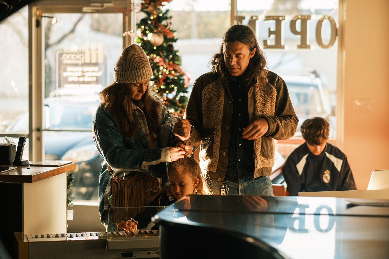 Family shopping at a store decorated with a Christmas tree during the holiday season.