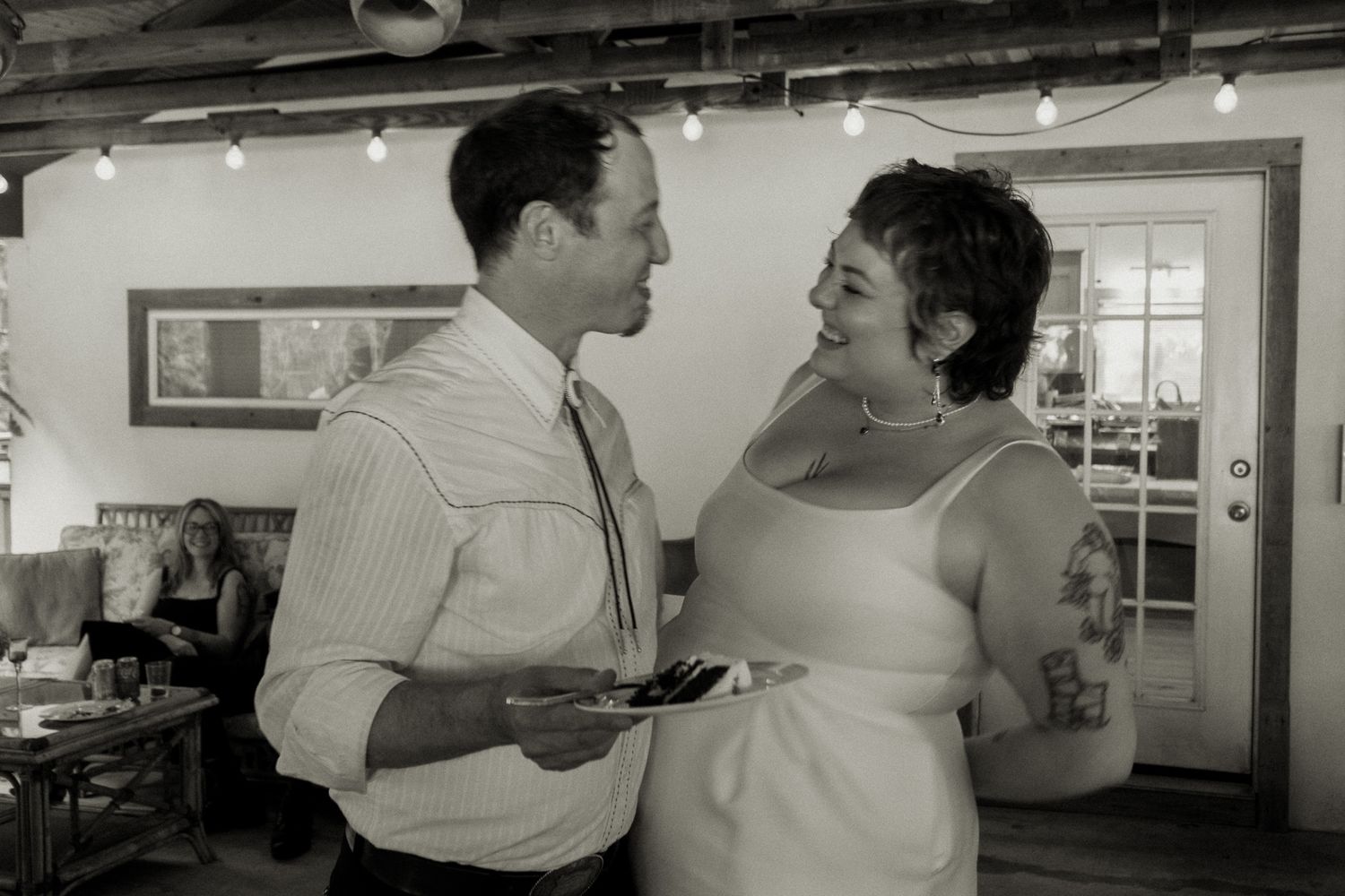 Black and white photo of bride and groom sharing a tender moment together at wedding reception.