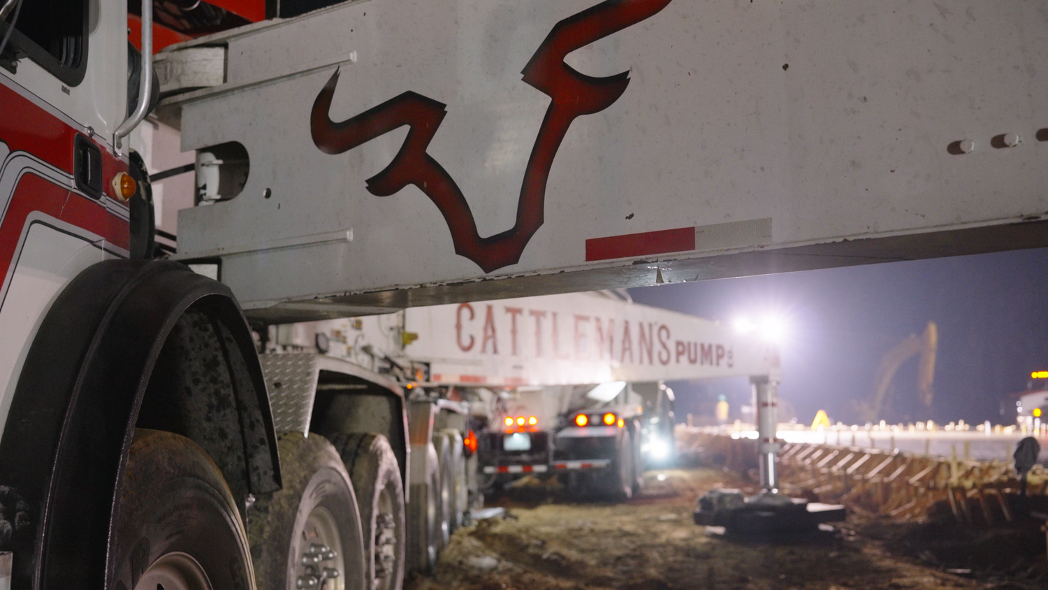 Cement pump delivering concrete at nighttime job site captured by Kin & Lens Creative Media construction photography Frisco Texas