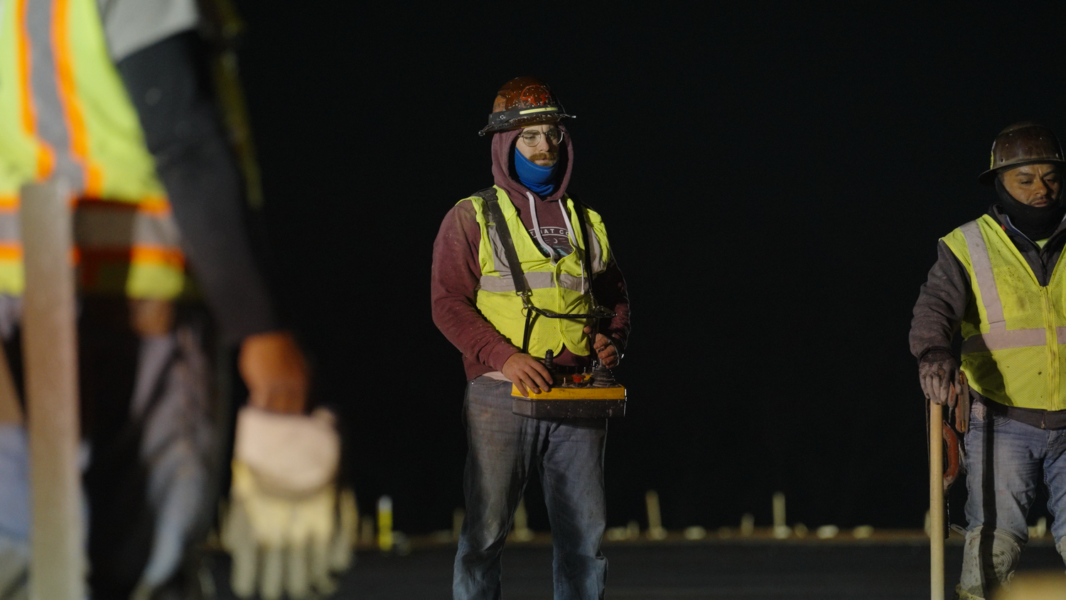 Construction crew preparing concrete pour on nighttime job site photographed by Kin & Lens Creative Media construction photographer Dallas