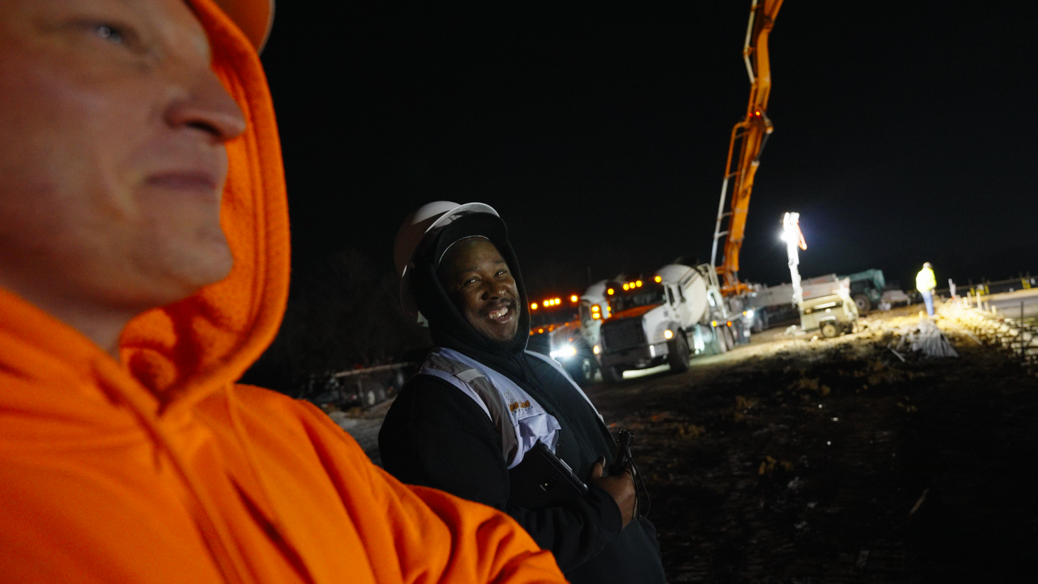 Construction workers observing active nighttime job site captured by Kin & Lens Creative Media construction photographer in Dallas Texas