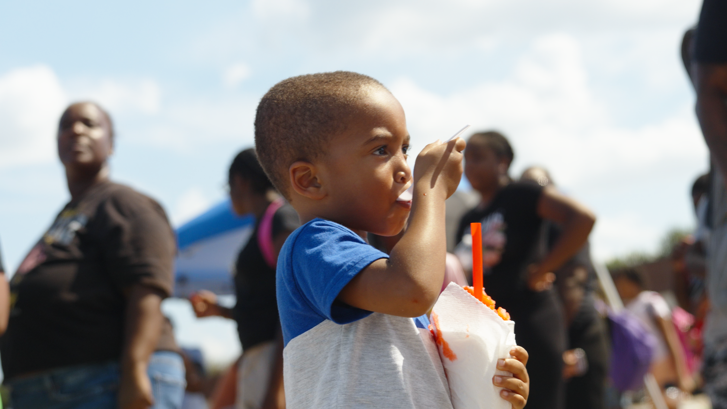 Child enjoying outdoor community celebration captured by Kin & Lens Creative Media event photographer in Dallas Fort Worth