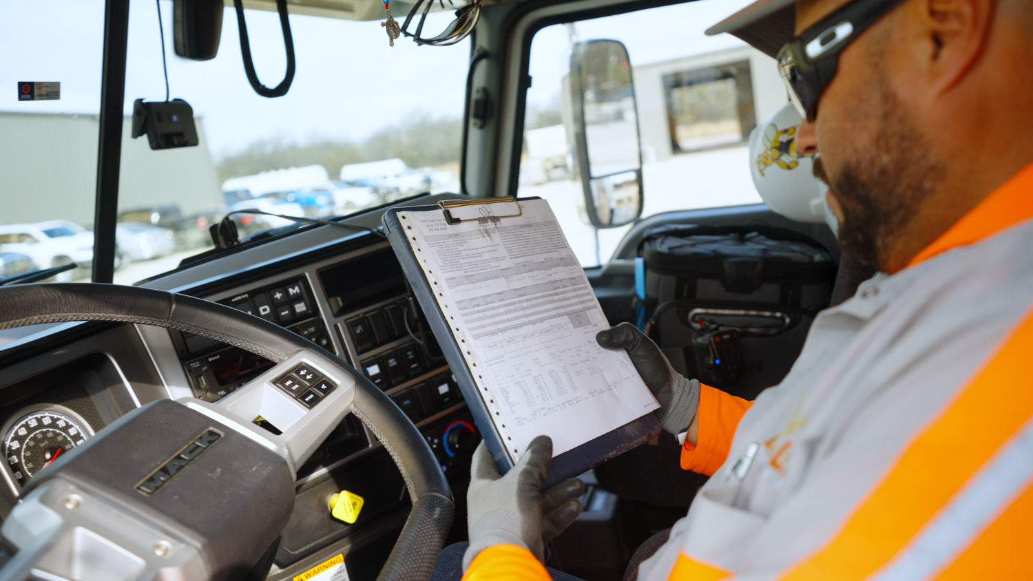 Concrete truck driver reviewing paperwork captured by Kin & Lens Creative Media construction photographer in Dallas Fort Worth