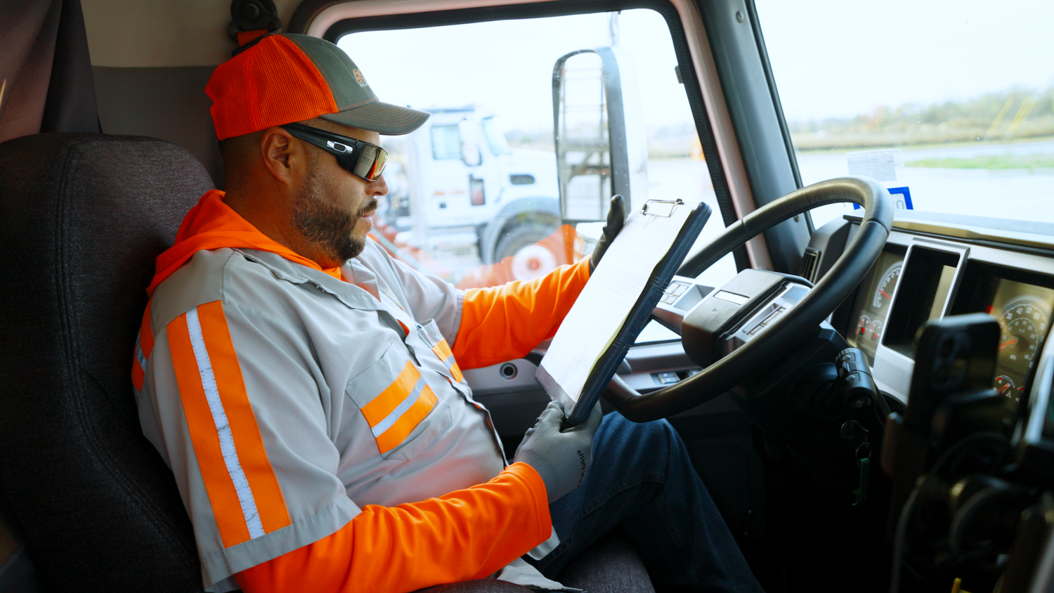 Concrete truck driver inside cab reviewing route captured by Kin & Lens Creative Media construction photographer in Dallas Fort Worth