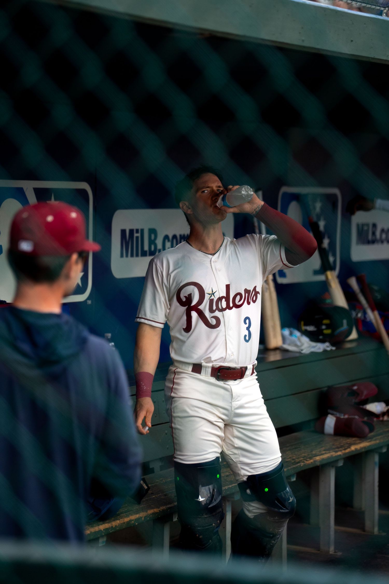 Baseball player in dugout during game captured by Kin & Lens Creative Media sports photographer in Dallas Fort Worth