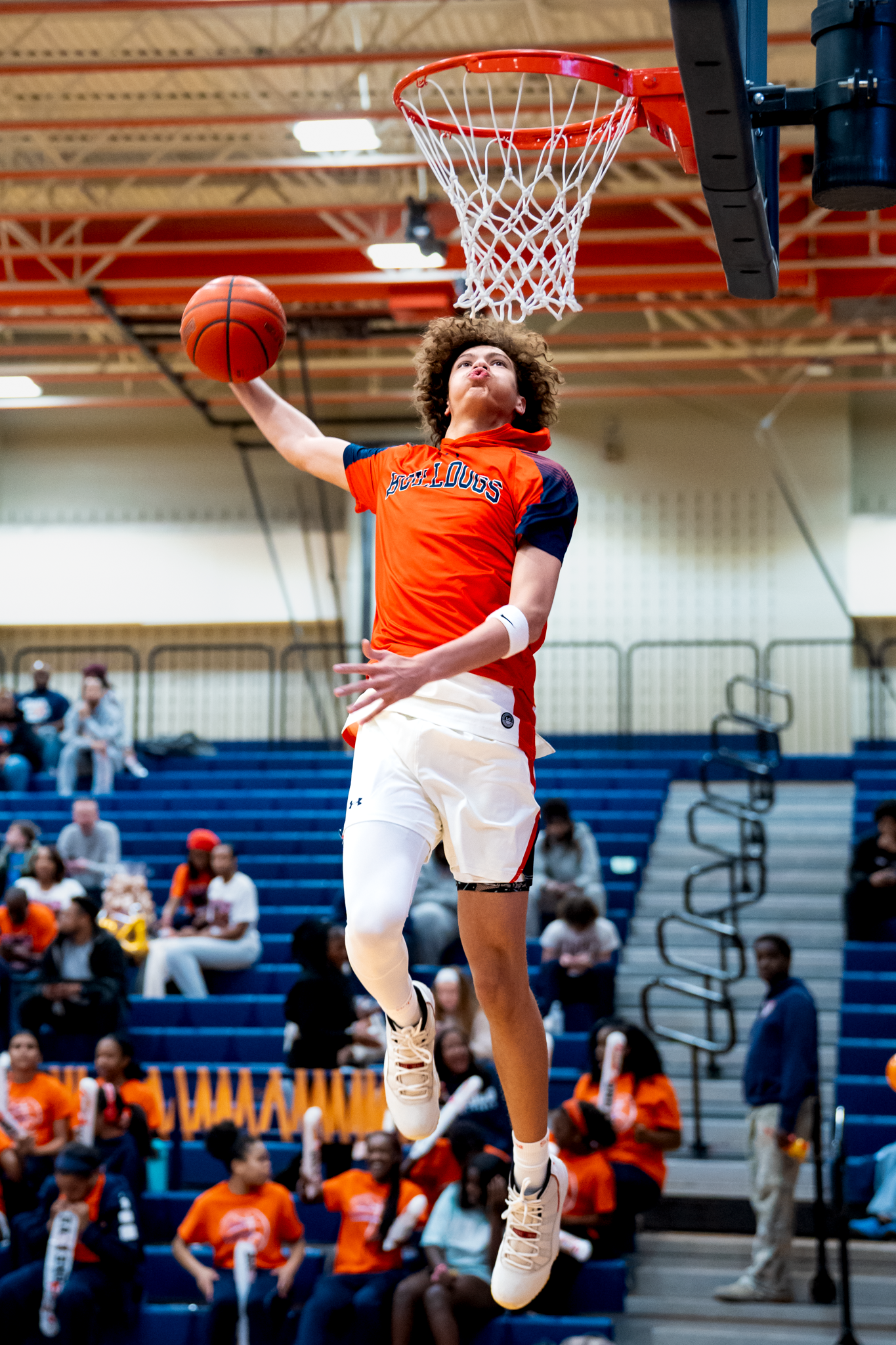 Basketball player performing dynamic slam dunk sequence in McKinney, TX gymnasium by Kin & Lens Creative Media.