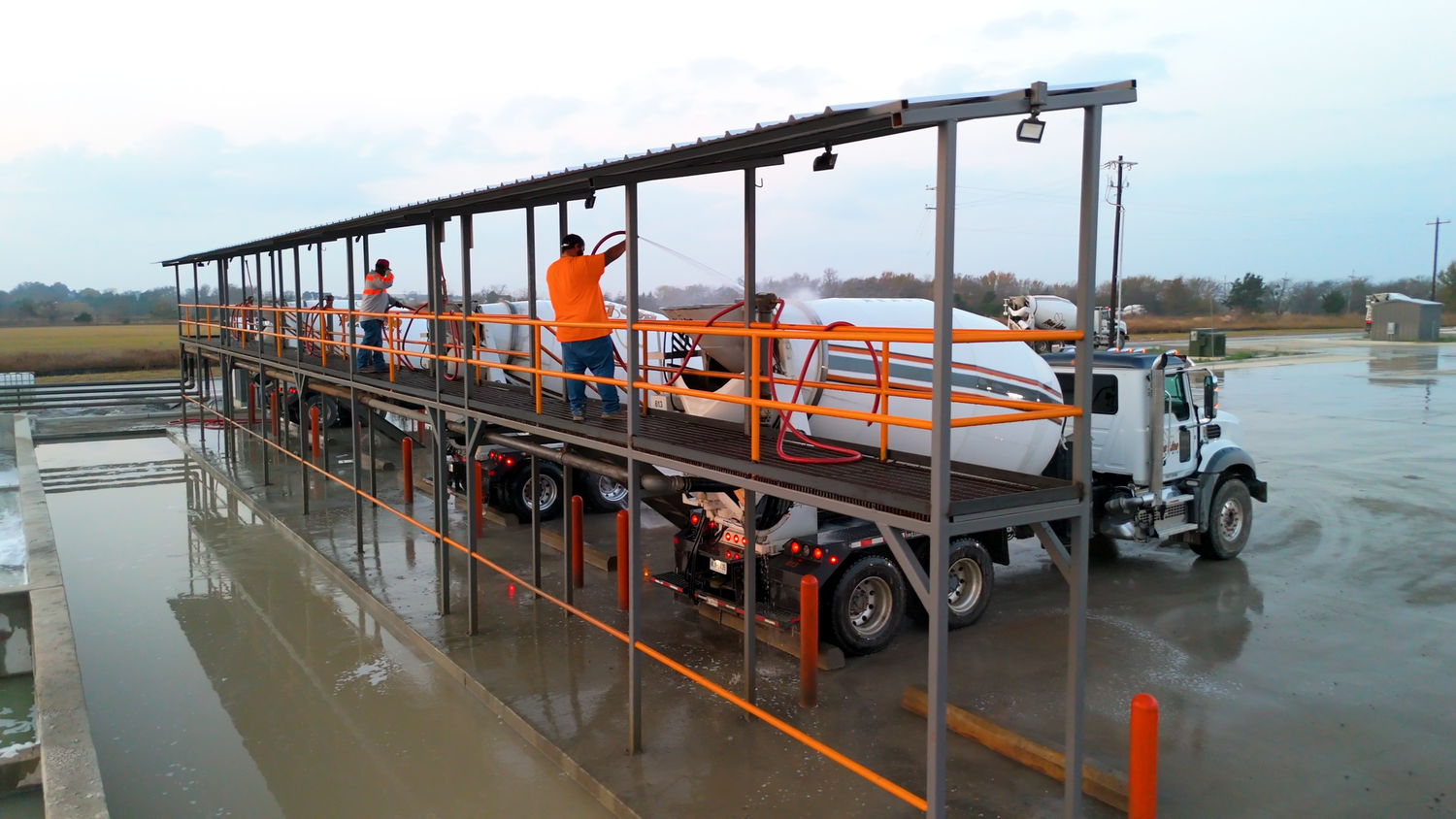 Concrete mixer trucks at washout station captured by Kin & Lens Creative Media construction photographer in Dallas Fort Worth