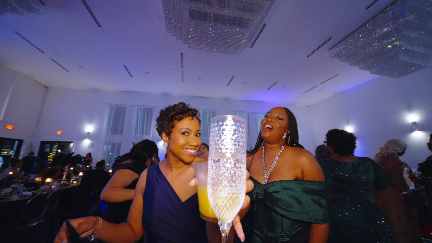 Guests celebrating with illuminated champagne flute captured by Kin & Lens Creative Media event photographer Dallas Fort Worth