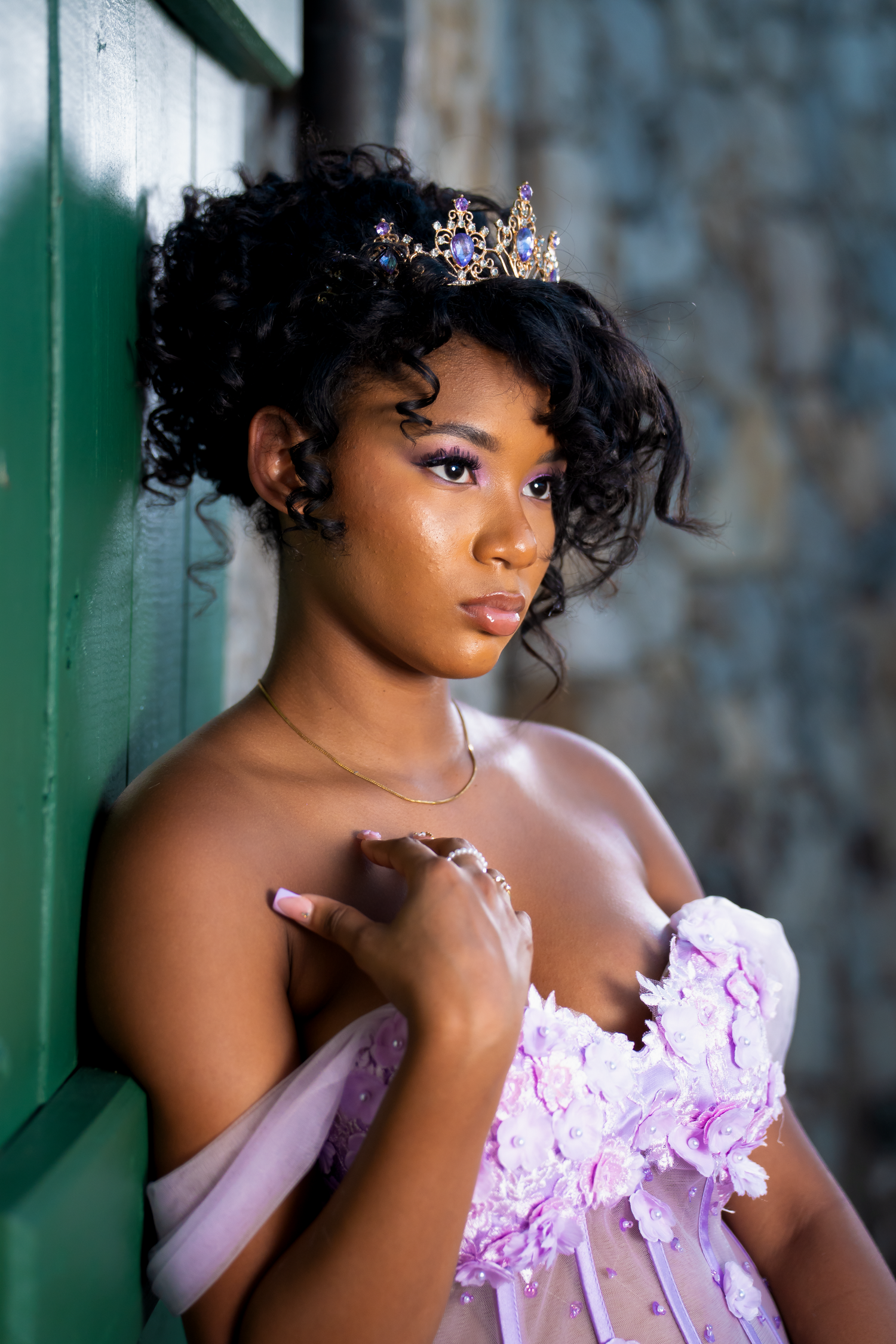 A portrait series showing someone in a pink strapless gown with lace details against a green wall background shot by Kin & Lens Creative