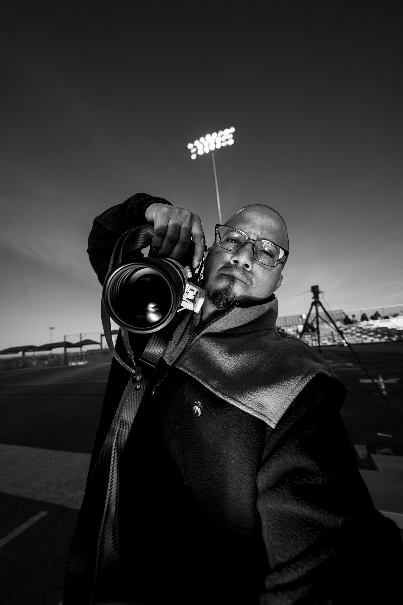 Black and white portrait of photographer using professional camera equipment in McKinney, TX by Kin & Lens Creative Media