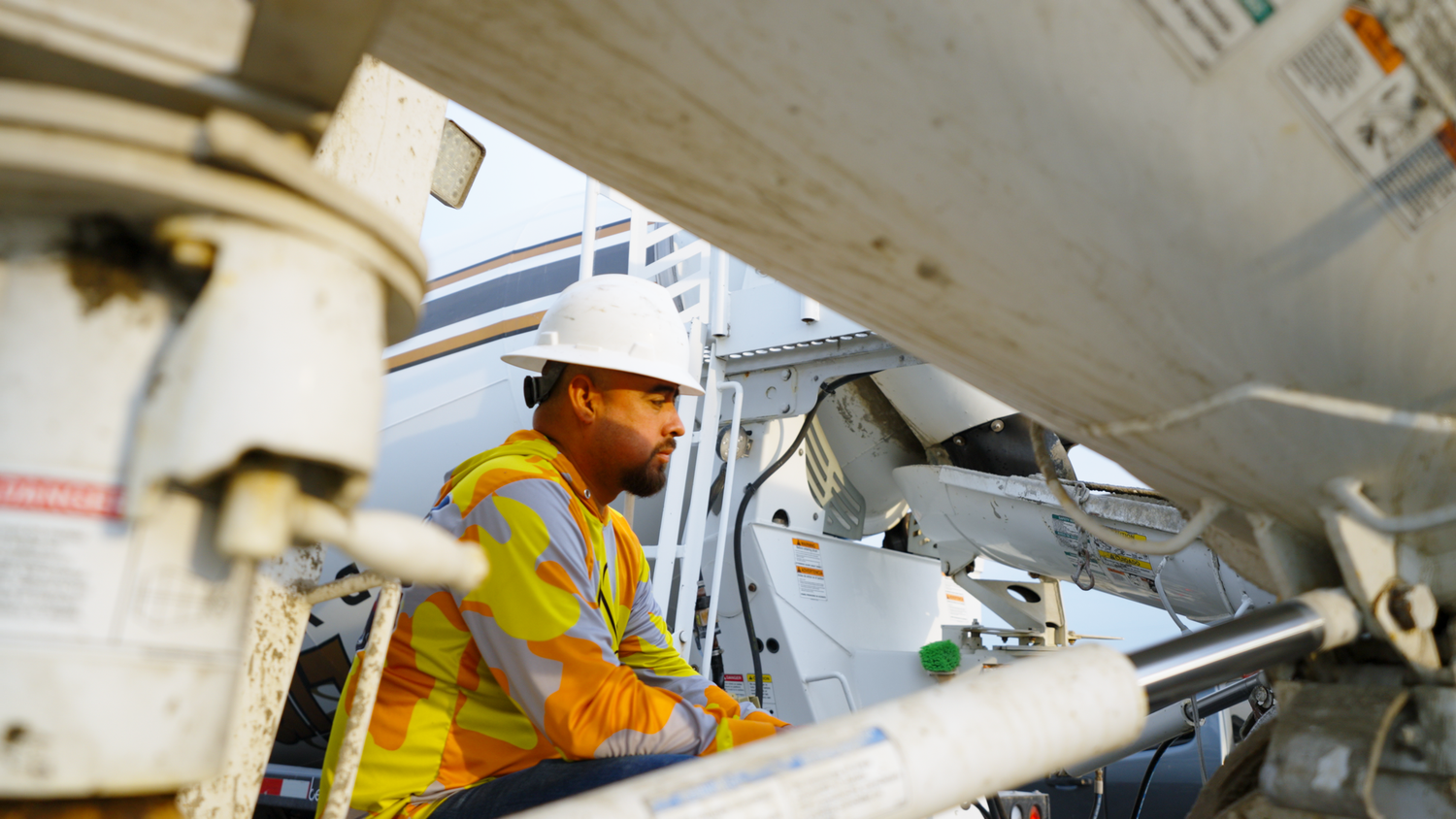 Construction worker inspecting concrete mixer truck captured by Kin & Lens Creative Media construction photographer in Dallas Fort Worth