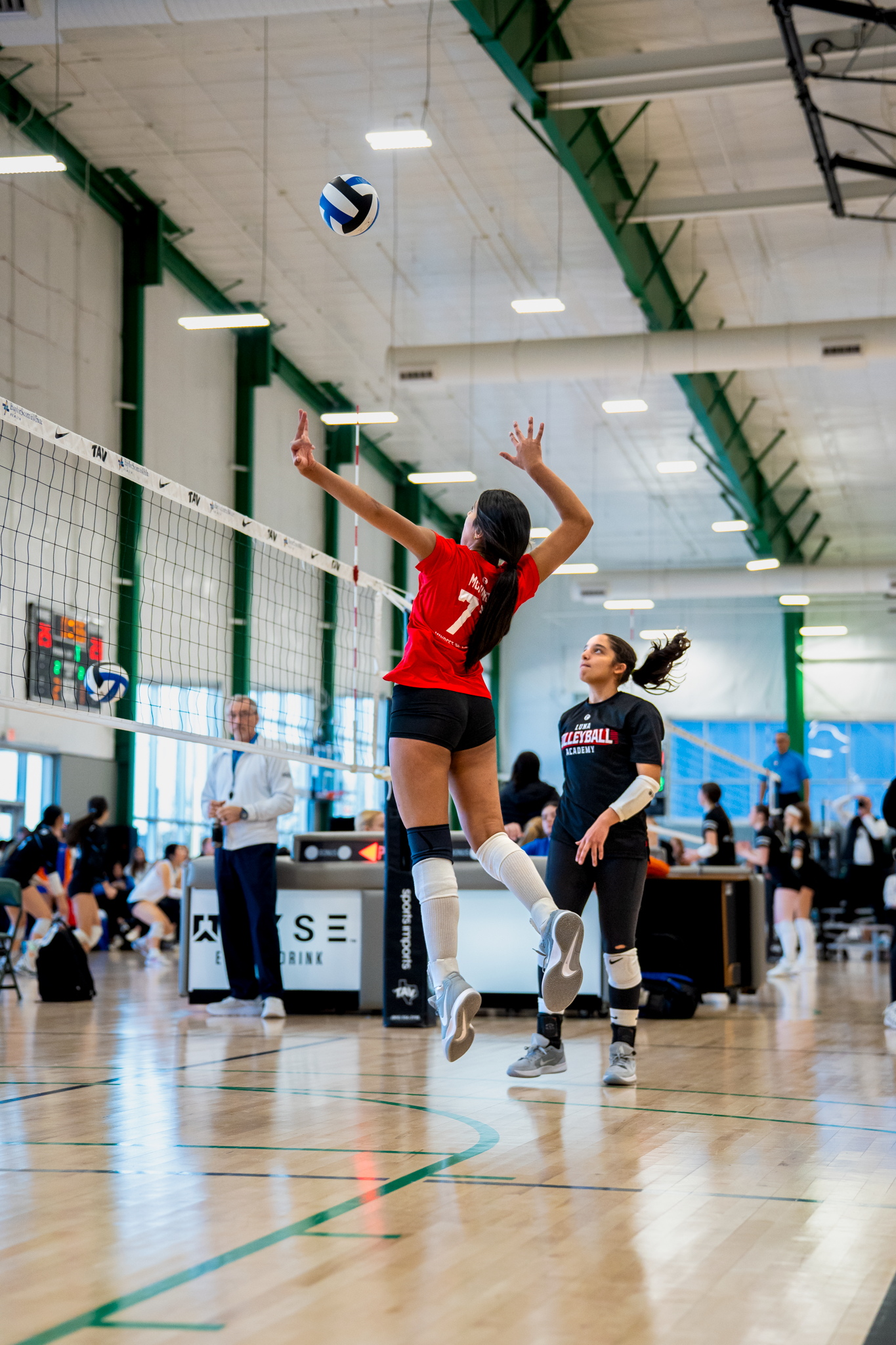 Indoor volleyball players in Dallas, TX action during an intense match sequence by Kin & Lens Creative Media.