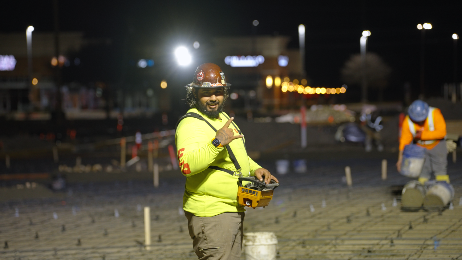 Construction worker standing on rebar grid during night concrete job captured by Kin & Lens Creative Media construction photographer DFW