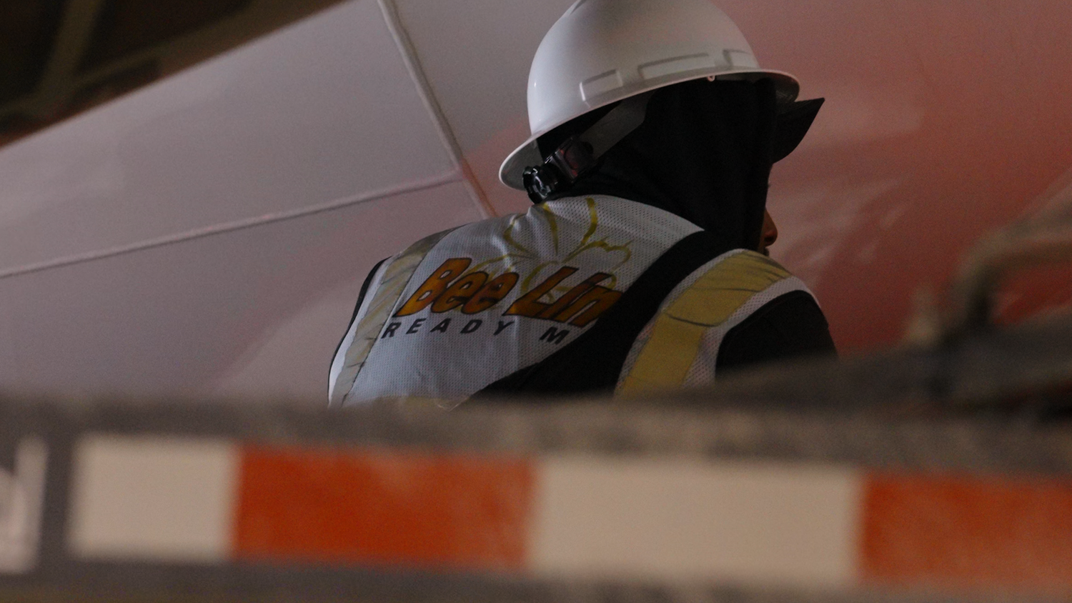 Construction worker wearing hard hat on active job site captured by Kin & Lens Creative Media construction photographer in DFW