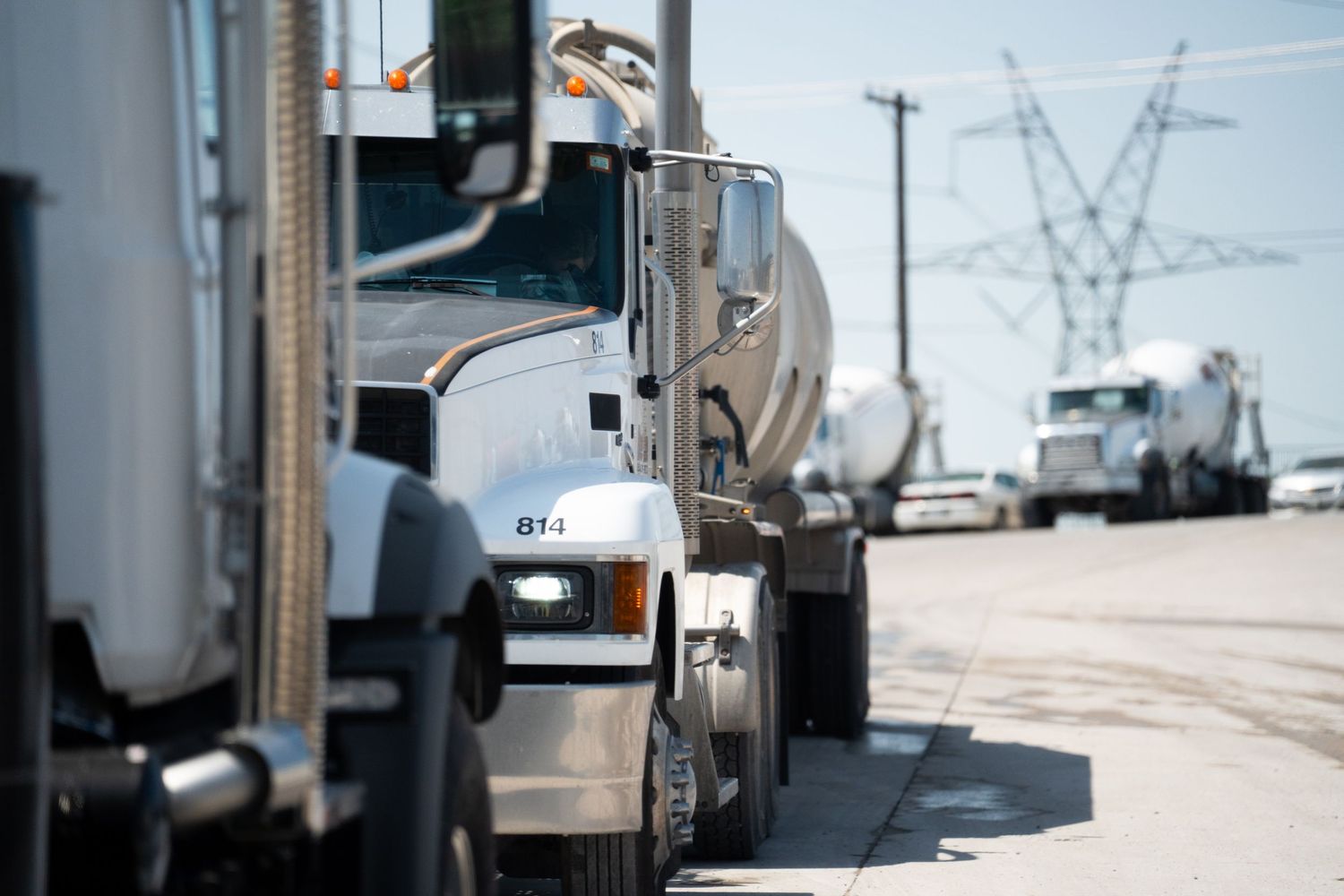 Concrete mixer trucks lined up on roadway captured by Kin & Lens Creative Media construction photographer in Dallas Fort Worth