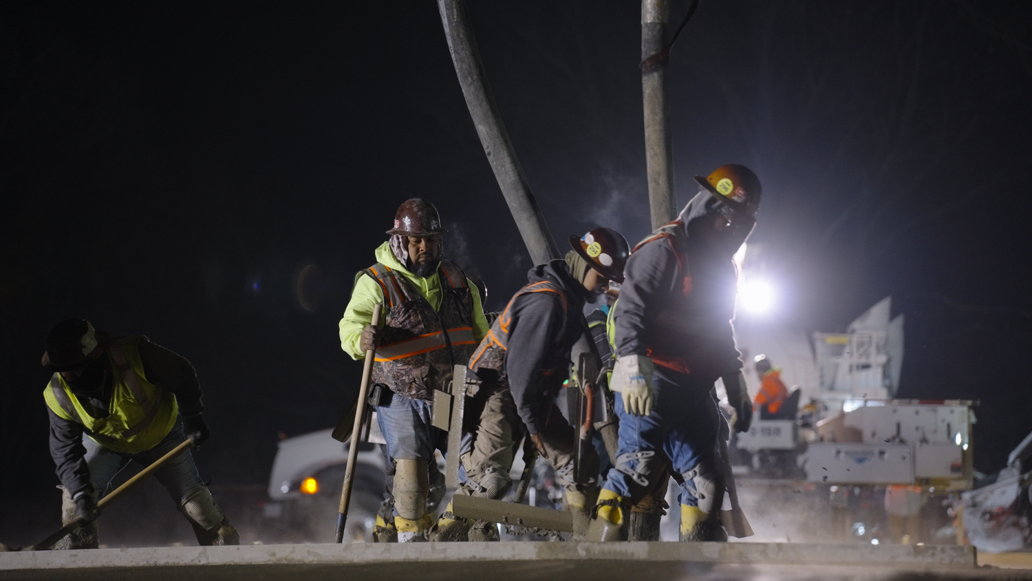 Concrete crew finishing freshly poured slab at night captured by Kin & Lens Creative Media construction photographer Dallas Fort Worth
