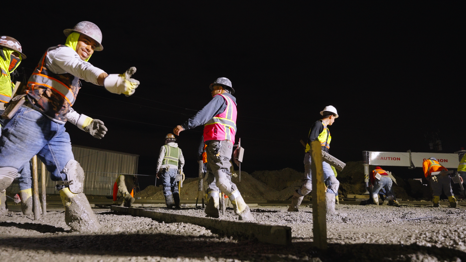 Concrete crew directing slab pour on job site captured by Kin & Lens Creative Media construction photographer in Dallas Fort Worth