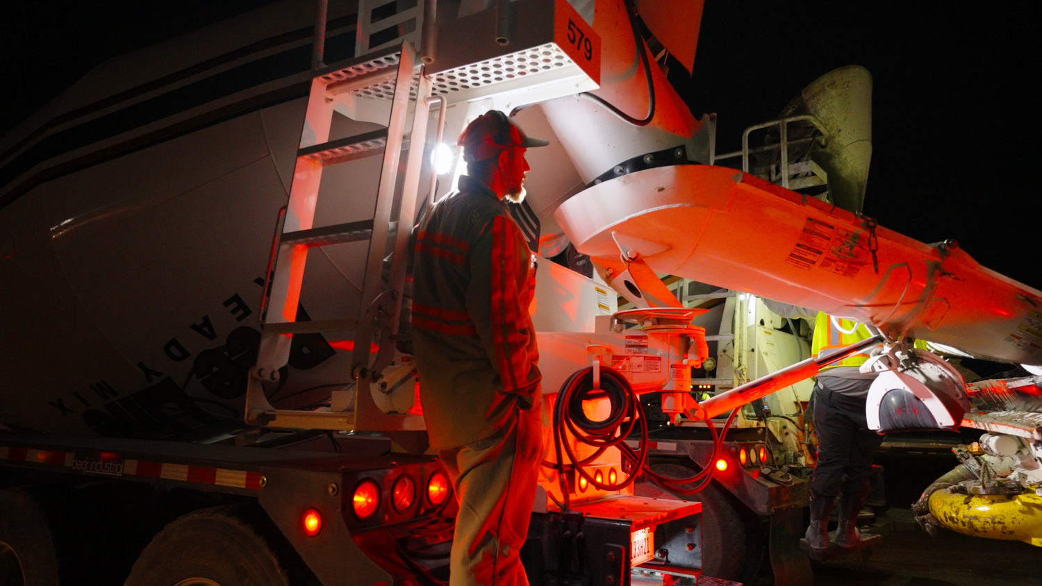 Construction worker operating cement mixer truck captured by Kin & Lens Creative Media construction photographer in Dallas Fort Worth