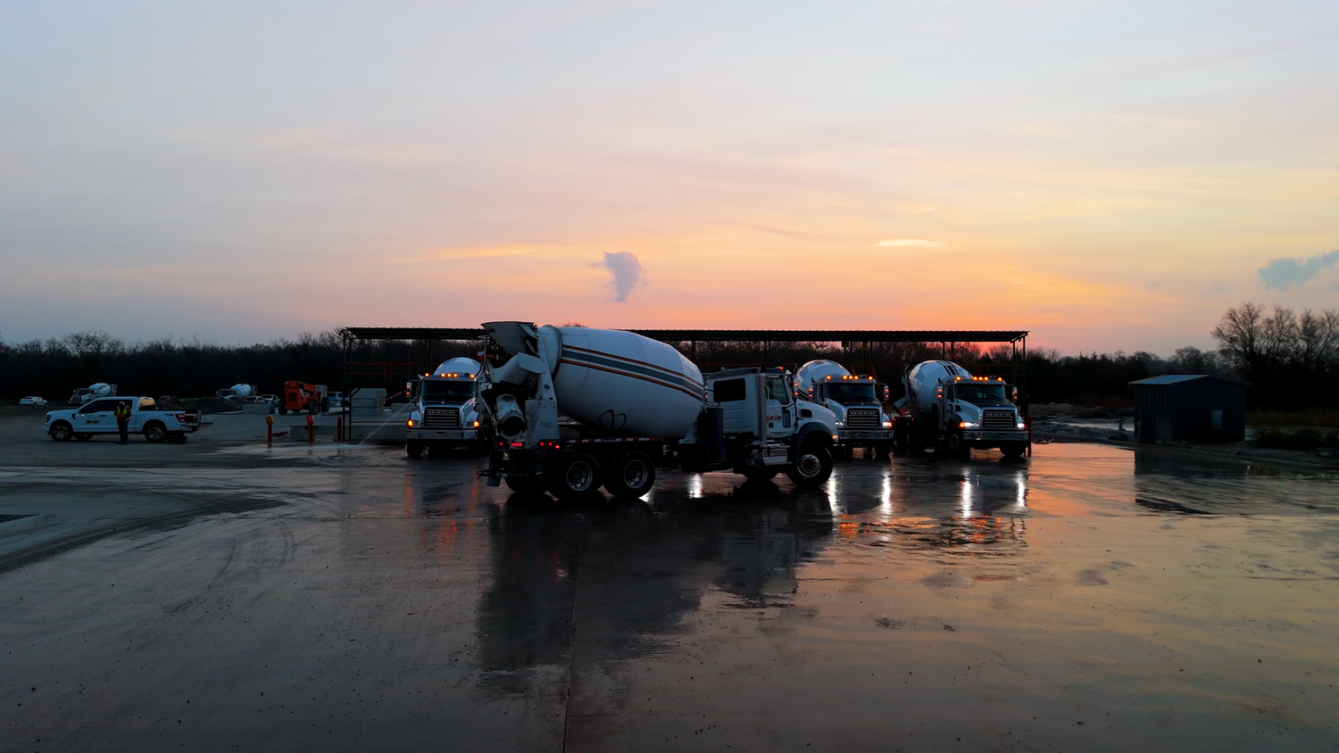 Concrete mixer trucks lined up at sunrise captured by Kin & Lens Creative Media construction photographer in Dallas Fort Worth