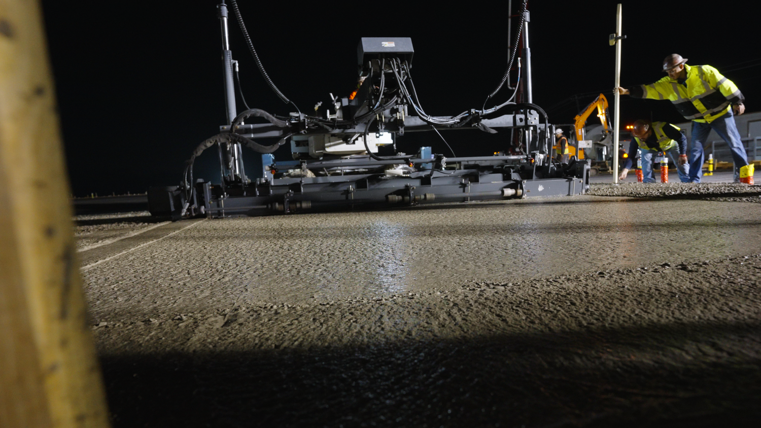 Concrete crew leveling freshly poured concrete captured by Kin & Lens Creative Media construction photographer in Dallas Fort Worth