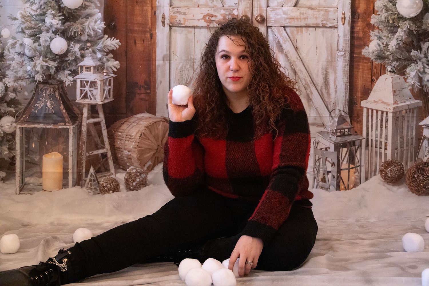 Cozy Christmas photo session with rustic wooden backdrop and festive holiday decorations.