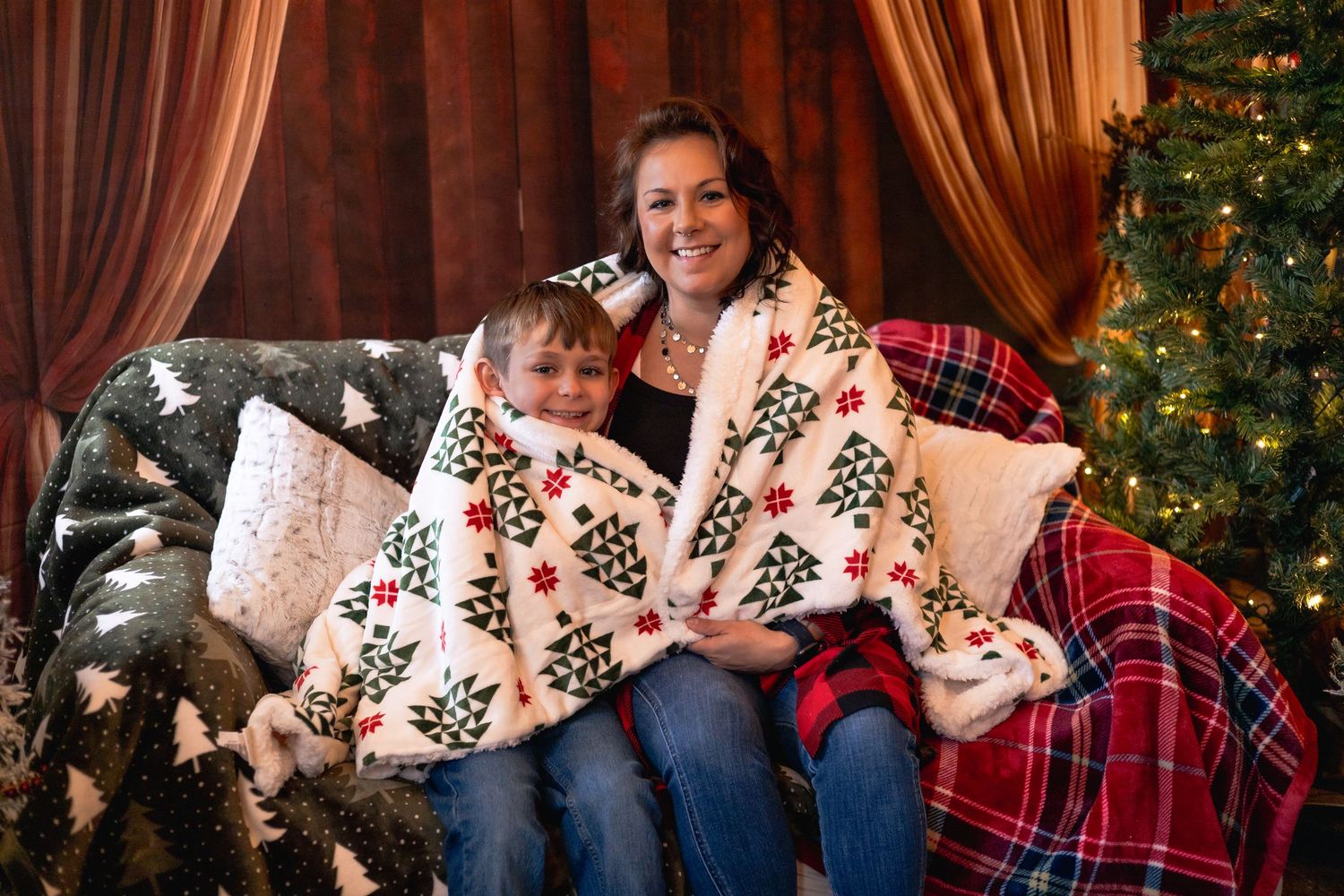 A cozy Christmas scene with a patterned blanket and decorated tree in the background.