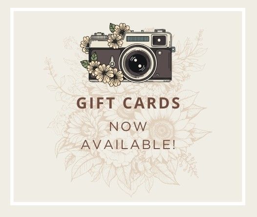 Vintage style camera with floral decorations and gift cards text on a light beige background.