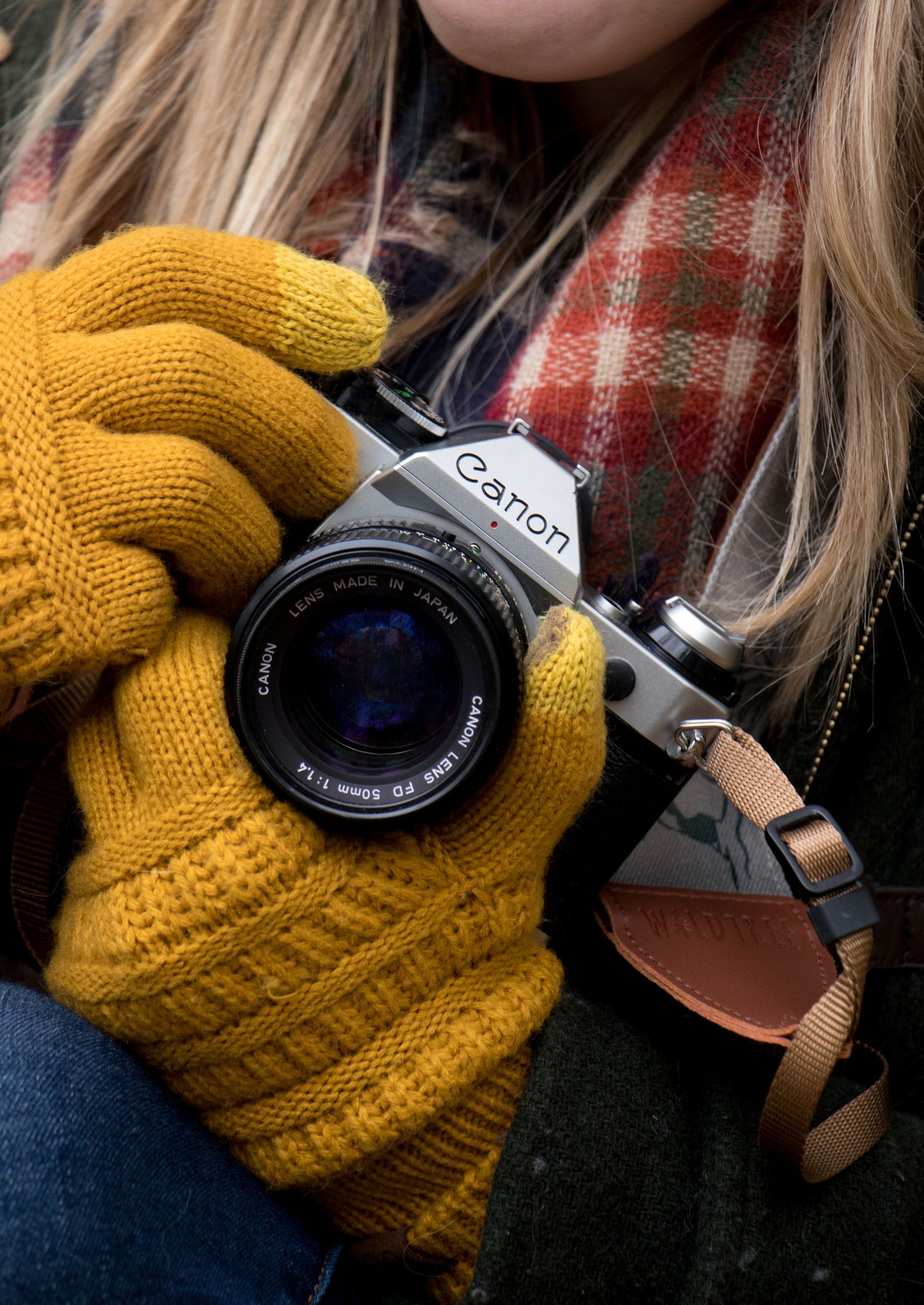 A detail shot shows a Kansas City photographer's hands holding a film camera wearing mustard yellow gloves and a plaid scarf.