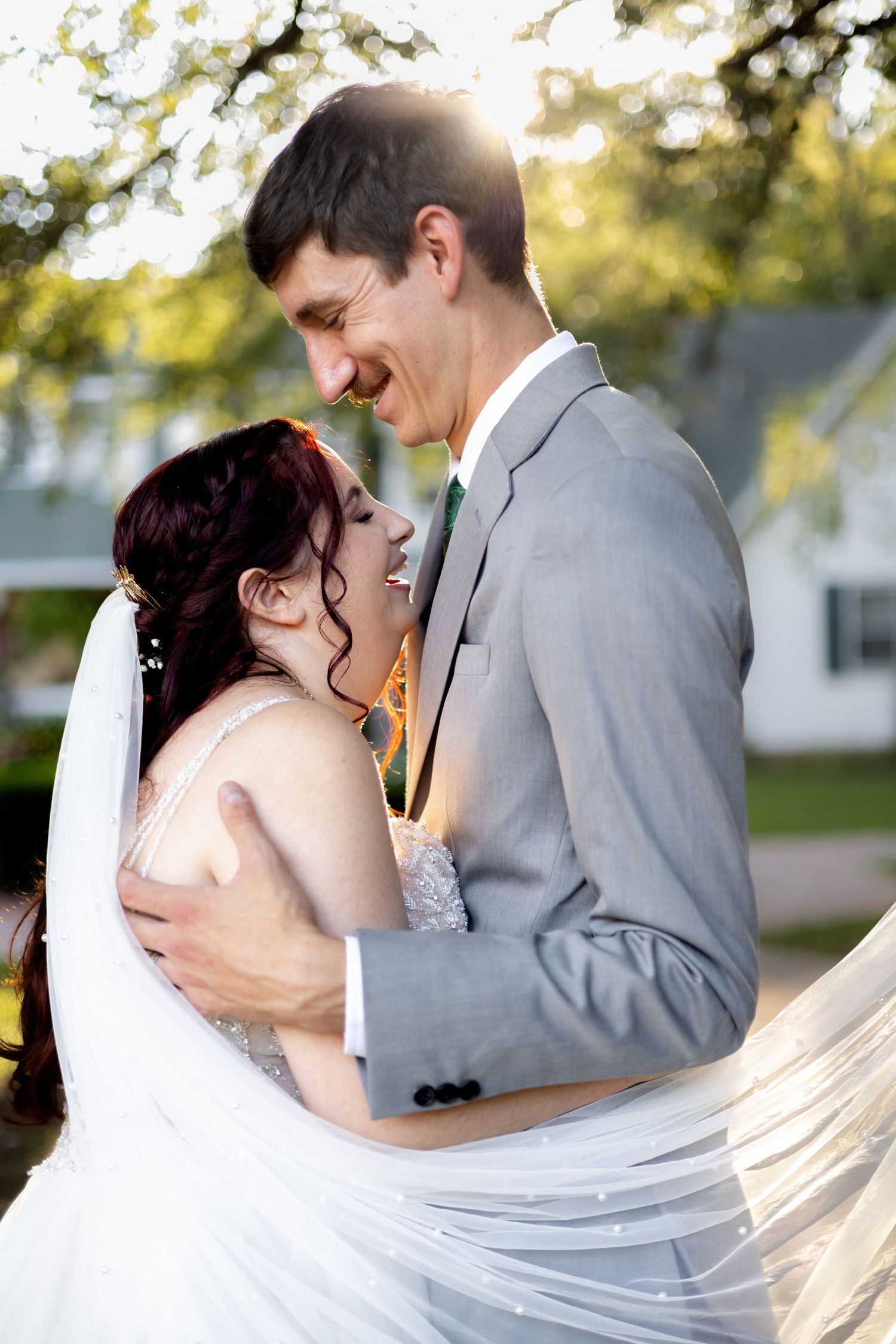 A romantic wedding couple shares intimate kisses in a series of dreamy outdoor portraits with flowing white veil details.