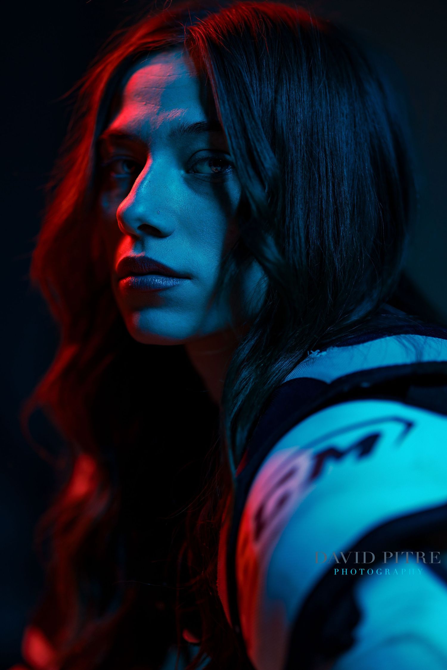 Cinematic portraits with dramatic red and blue lighting against dark background.