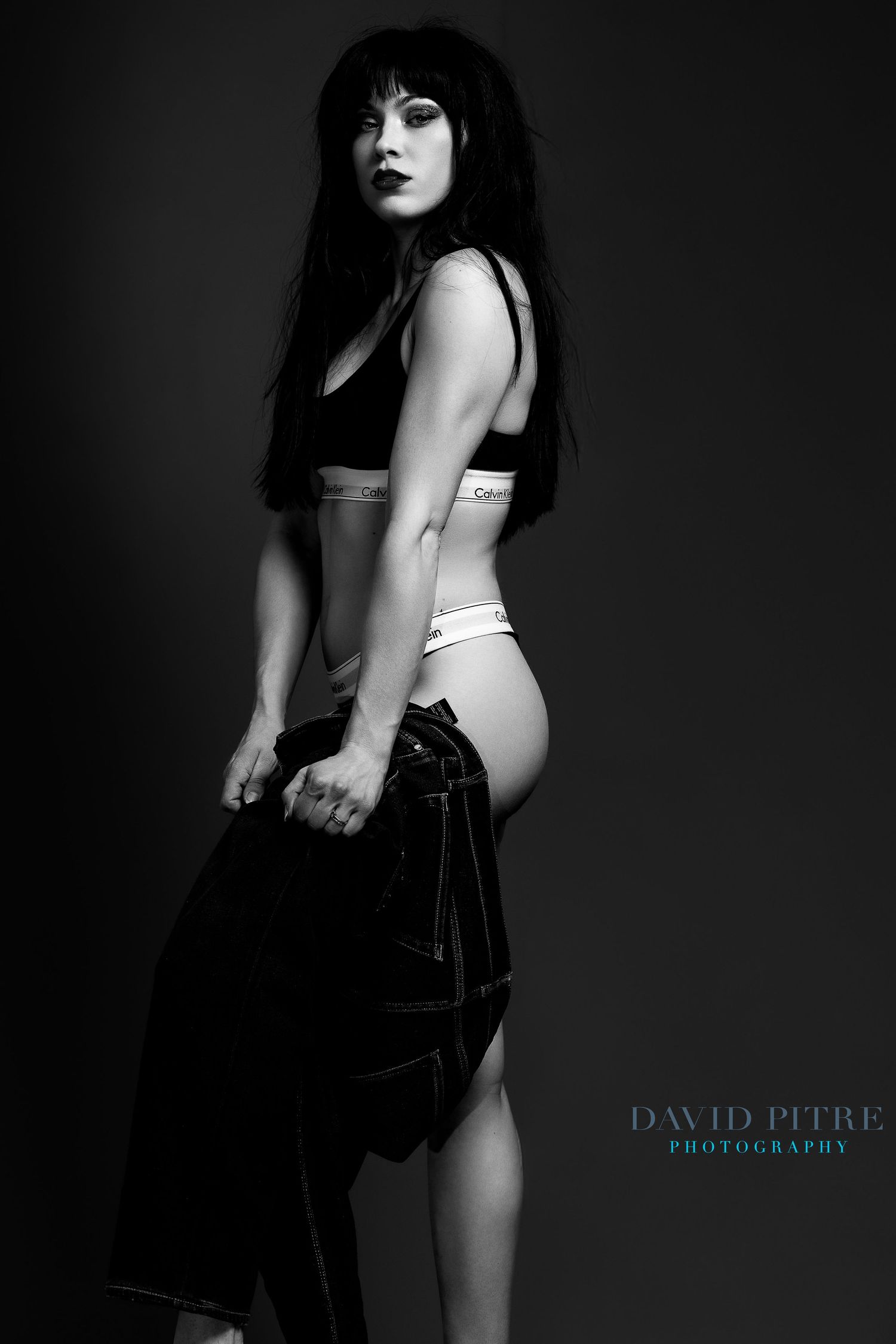 Dramatic black and white fashion photograph showing Calvin Klein underwear collection with denim styling.