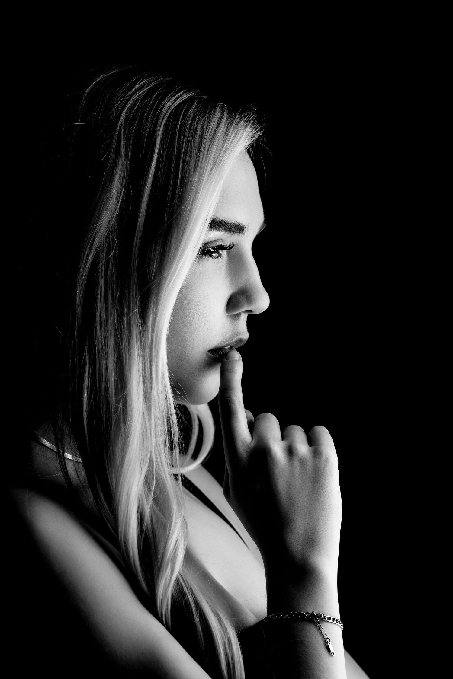 A dramatic black and white photo series showing a woman in profile with blonde hair touching her face in contemplative poses.
