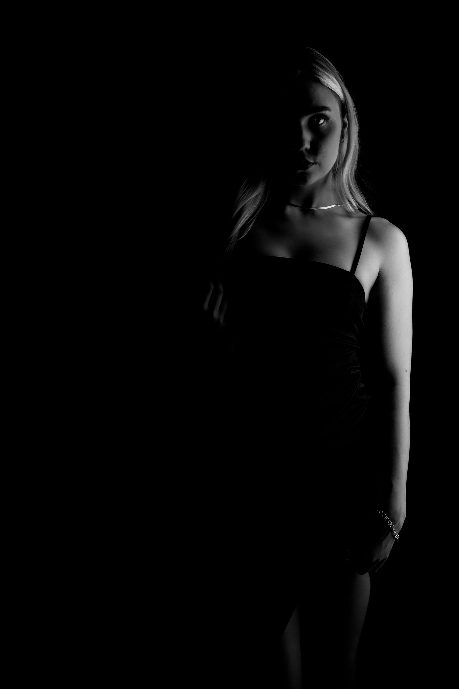 A dramatic black and white portrait series showing silhouettes against dark backgrounds in artistic poses.