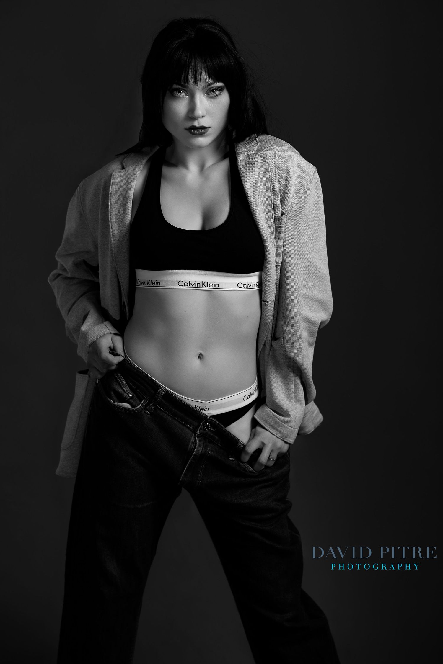 Black and white fashion photo showing Calvin Klein underwear styling with casual denim and hoodie.