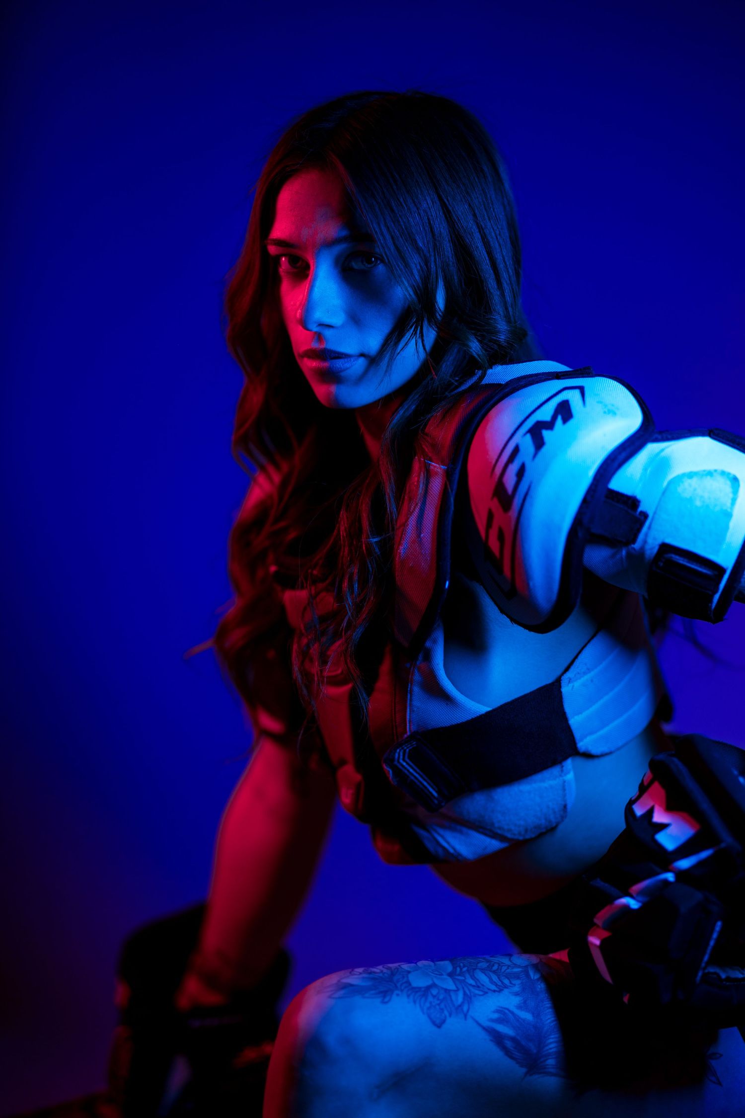 A dramatic portrait series lit with contrasting red and blue lighting against a dark background.