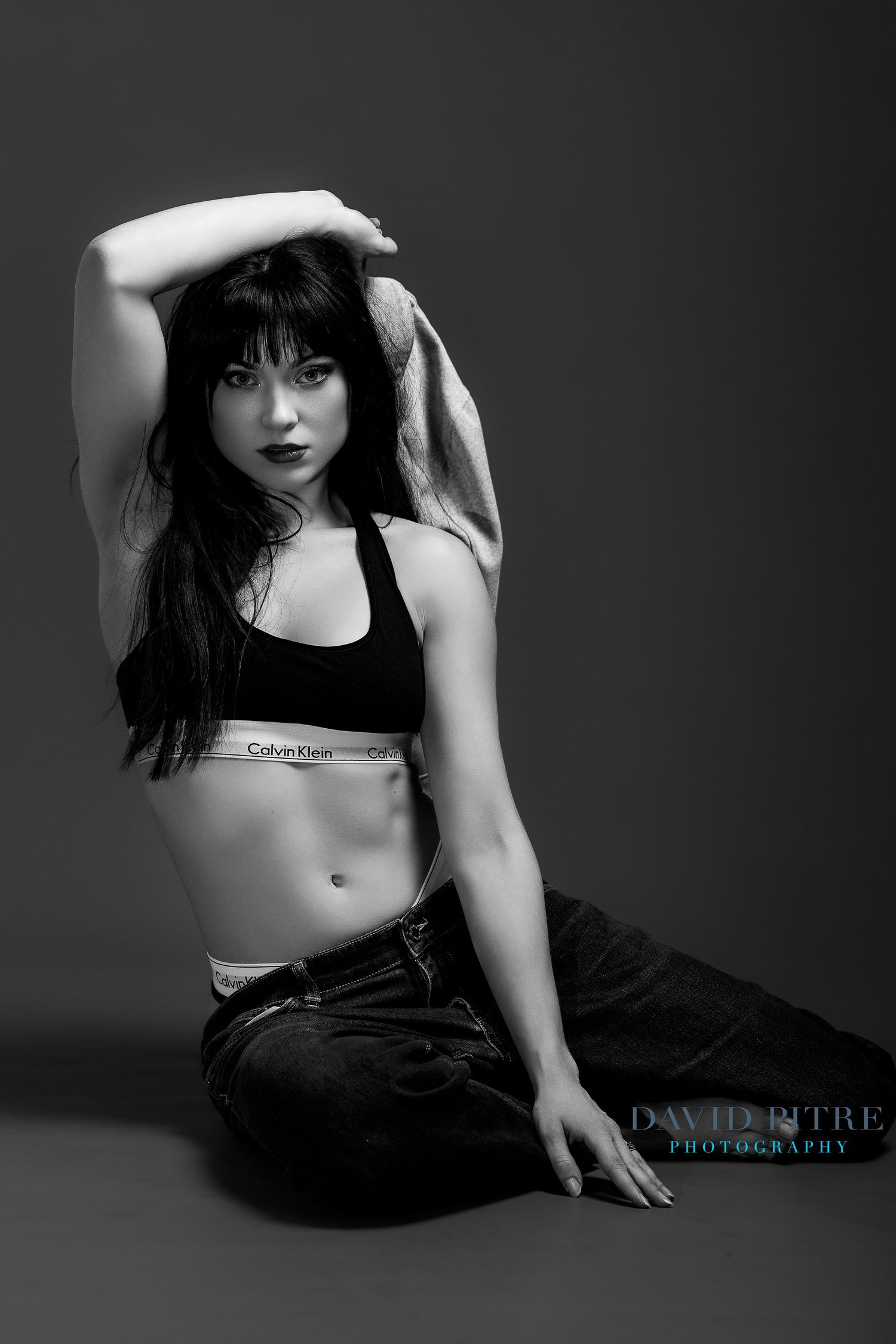 Artistic black and white boudoir photography series showing moody poses against dark background in studio setting.