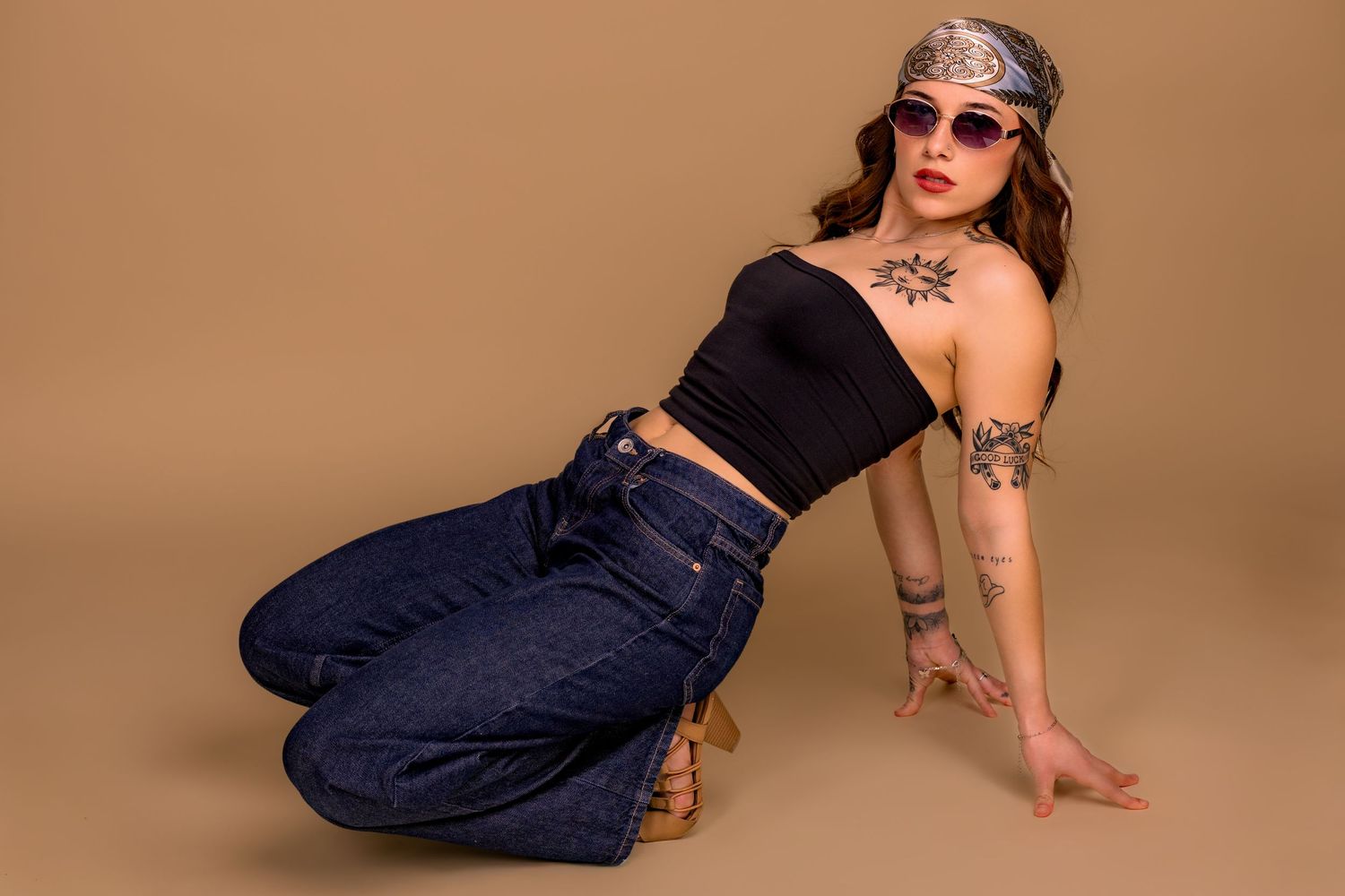 A person in dark denim jeans and black top poses against a beige background in a dynamic fashion sequence.