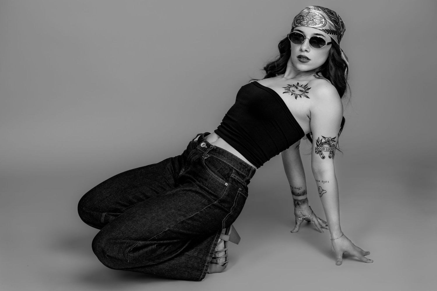 A series of black and white fashion photos showing denim jeans and boots in various artistic poses against a studio backdrop.