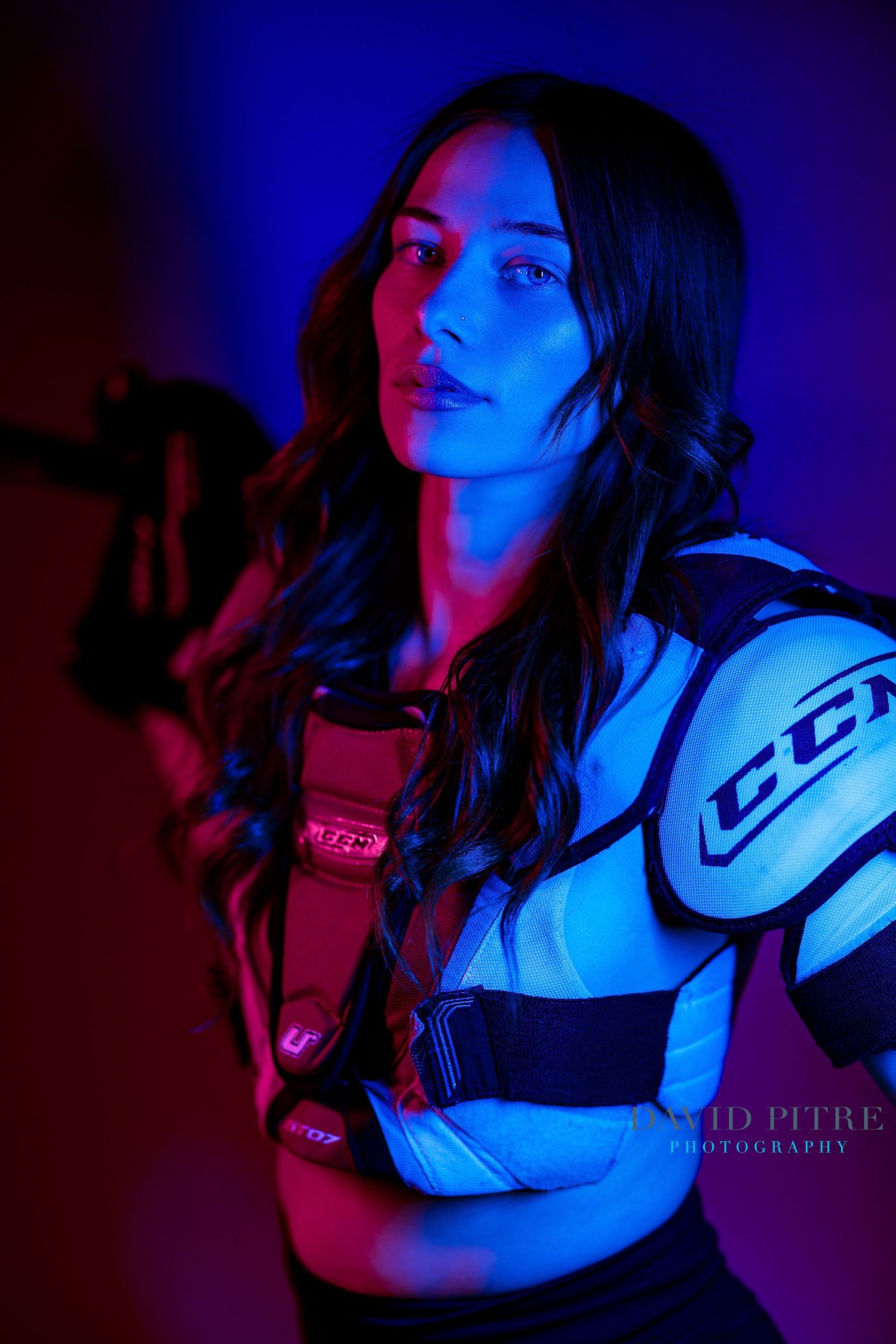 Artistic fashion portrait illuminated by vibrant red and blue neon lighting effects.