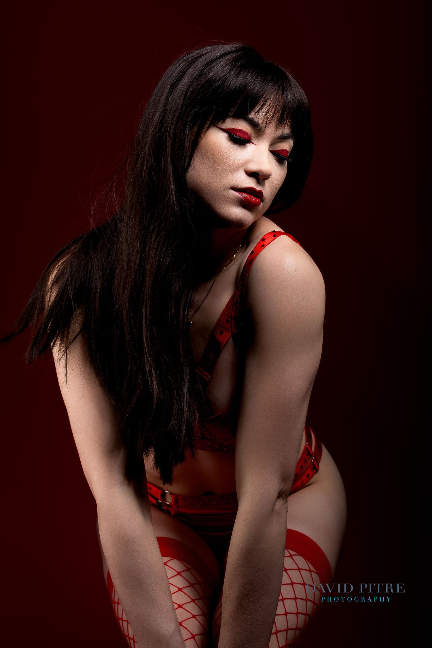A series of dark and moody fashion portraits featuring a model in red fishnet and dramatic lighting against a black background.