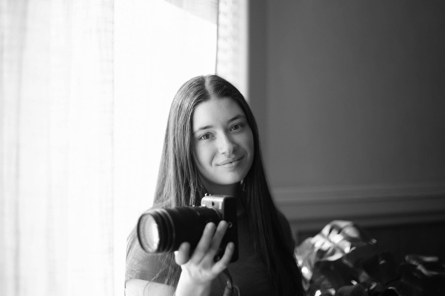 a photographer holds her camera at her studio in Bend, Oregon