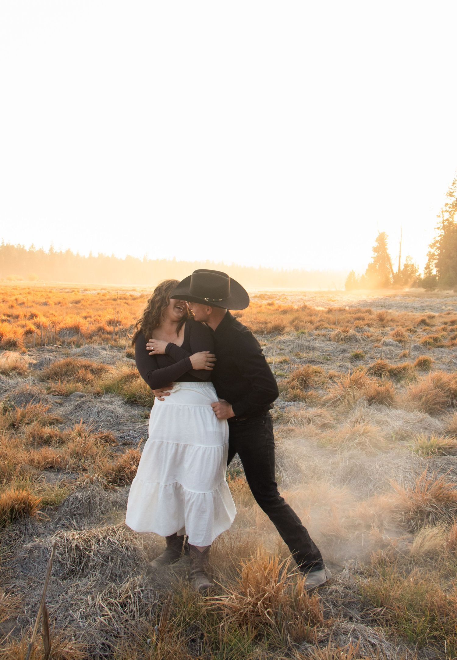 a couple dances in a dusty, Central Oregon field at golden hour
