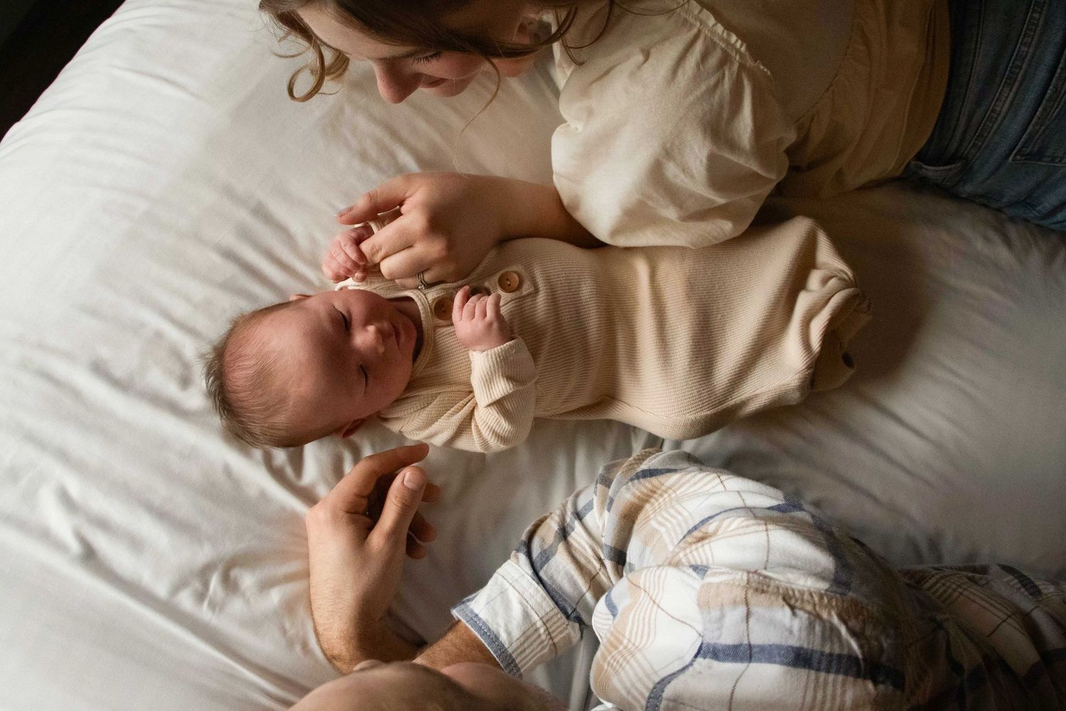 a mom and dad lay beside their newborn baby in their home in Bend, Oregon